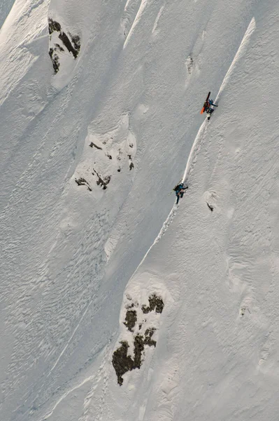 Krásný letecký pohled na zimní hory a statečné lyžaře šplhající na něj — Stock fotografie