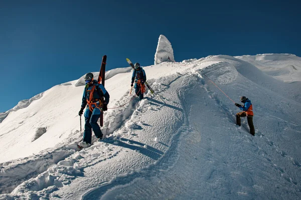 Men skiers with backpacks and ski equipment walking on snowy ridge — ストック写真