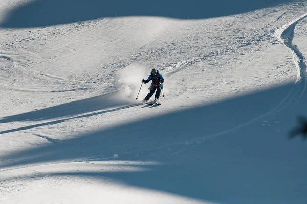 Homem freerider com esqui desliza rapidamente por uma encosta de montanha coberta de neve em pó. — Fotografia de Stock