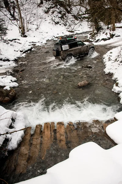 View on off-road vehicle driving through a mountain river at winter — Photo