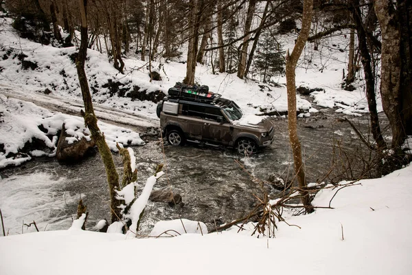 High angle view on off-road vehicle driving through a mountain river at winter — Stock Photo, Image