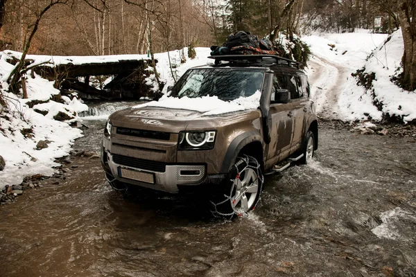 Close-up off-road vehicle ride across a mountain river at winter — Stock Photo, Image