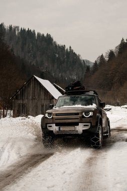 Dağlardaki karlı yolda modern off-road gezisi. Dağ turizmi taşımacılığı.