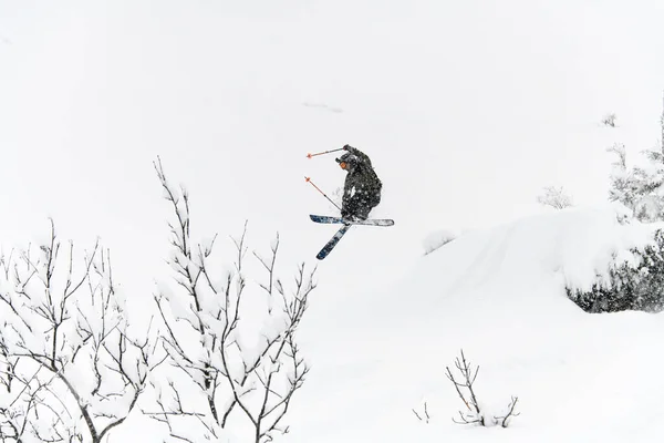 Shot of skier jump in the air over a snow-covered mountain slope. Freeride skiing concept — Fotografia de Stock