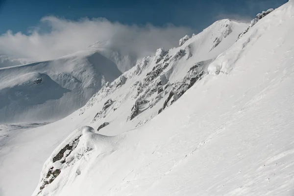 Beyaz kar ve mavi gökyüzü ile kaplı inanılmaz dağ yamaçları