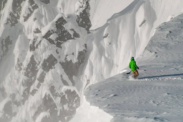 Bonito penhasco de montanha coberto de neve e alpinista com equipamento na borda dele — Fotografia de Stock