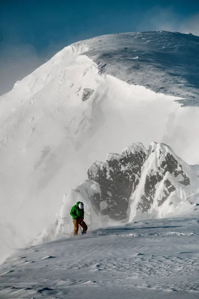 Kış karla kaplı dağ sırası ve üzerine tırmanan erkek. — Stok fotoğraf