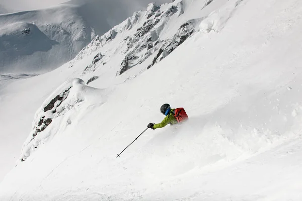 Bela encosta da montanha com neve em pó e esquiador está indo ativamente para baixo. Conceito de esqui Freeride — Fotografia de Stock