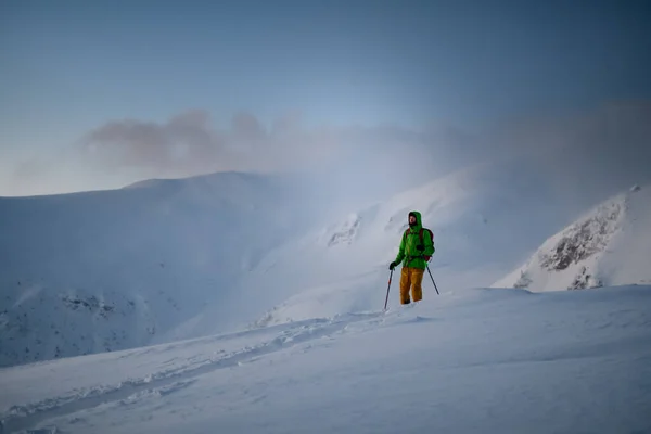 Homme skieur en costume de ski lumineux se lève et lève les yeux — Photo