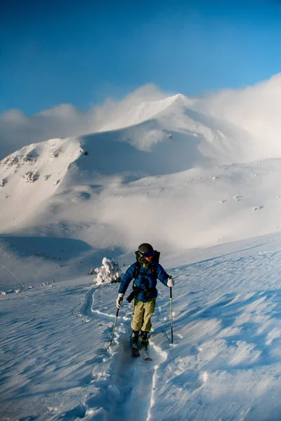 Male skier walking on deep white powdery snow path of snow-capped mountain Shpytsy in Ukraine — стоковое фото