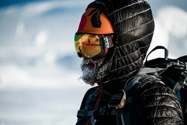 身穿黑色夹克，头戴滑雪头盔和护目镜，留着胡子的男子滑雪者的侧面肖像 — 图库照片