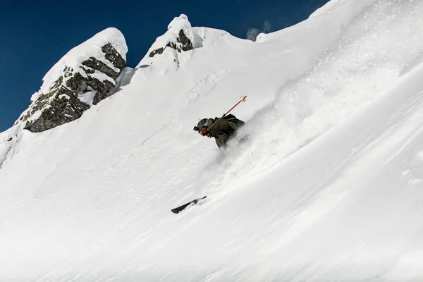 Freerider skier with go-pro camera on his helmet fast sliding down snow covered slope. — Fotografia de Stock