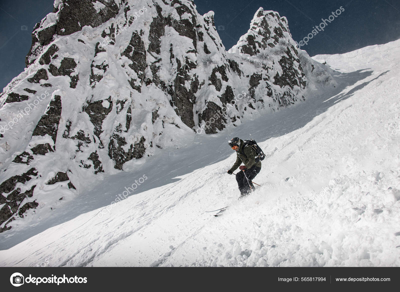 Skier dressed in brown and black sportswear with go-pro camera oh his  helmet sliding down snow-covered slopes Stock Photo by ©Fesenko 565817994