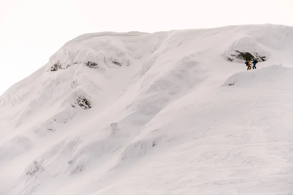 Great view of large snow-capped mountain with group of people rising to the top — Fotografia de Stock