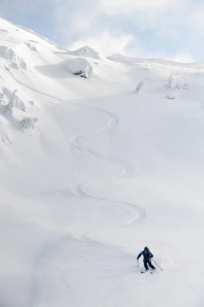 手付かずのパウダースノーを滑り降りるスノーボーダーの素晴らしい景色. — ストック写真