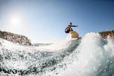 Su sıçratan dalganın güzel manzarası ve onun üzerinden atlayan adam.