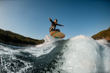 Uyanıkken ustalıkla sıçrayan dalgaların üzerinden atlayan aktif bir adam.