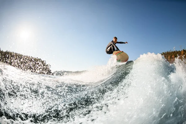 Su sıçratan dalganın güzel manzarası ve onun üzerinden atlayan adam.