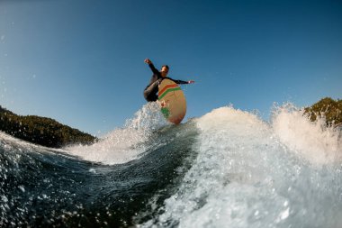 Su sıçratan dalganın muhteşem manzarası ve onun üzerinden atlayan adam.