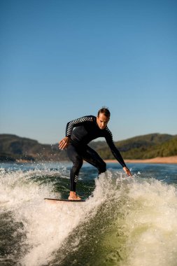 Aktif bir adam uyandığında dalgaların üzerinde durmaya çalışıyor.