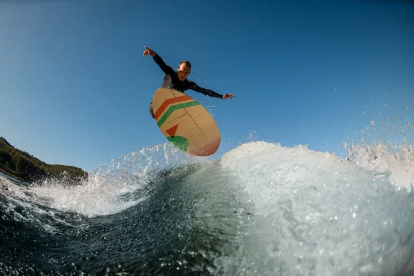 Active wakesurfer jumping on a wakesurf board over the river wave — 스톡 사진