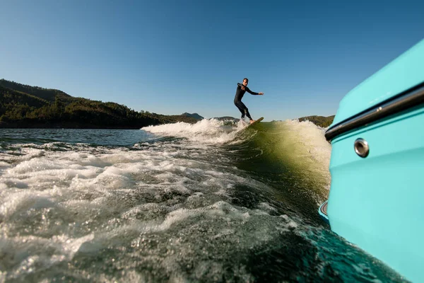 View on man on a wakesurf skillfully riding on a splashing wave — Stockfoto