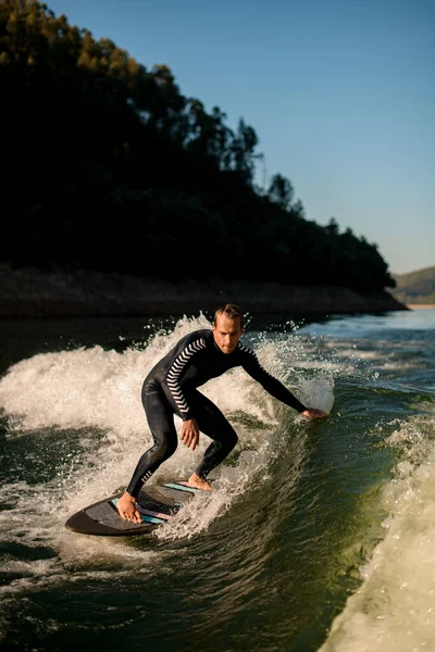 Active man on wakesurf skilfully riding down the splashing wave — Stockfoto