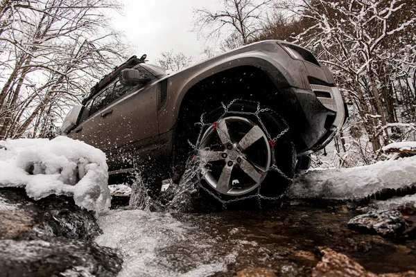 View of wheel of car with chains on wheels that drives on winter off-road — Stock Photo, Image