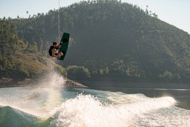 Aktif güçlü adam atlama zamanında wakeboard ile hile yapıyor