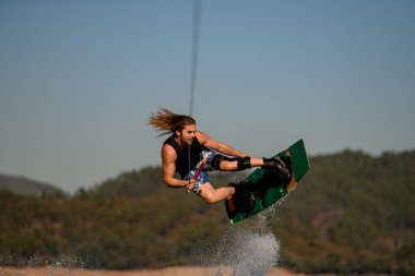 Yakışıklı, sağlıklı, aktif bir adamın Wakeboard 'da ustaca zıplamasının güzel manzarası.