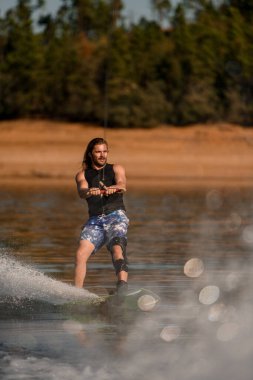 Halat tutan ve nehir yüzeyinde sörf yapan adamın manzarası harika.