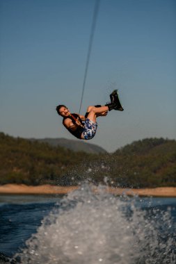 Wakeboard 'da zıplayan ve takla atan bir erkeğin enerjisinin harika görüntüsü.