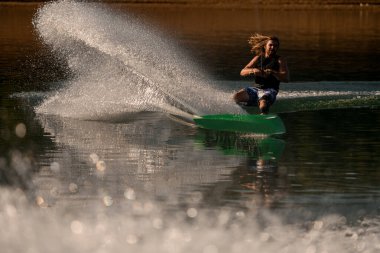 çekici ve enerjik erkek wakeboardda bir çok su birikintisi var.
