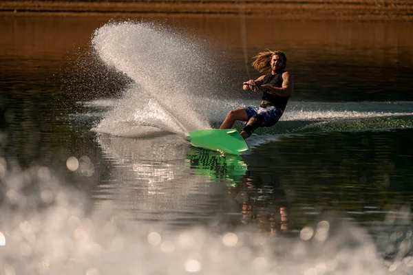 Vue de l'énergie mâle wakeboarder équitation de l'eau et beaucoup d'éclaboussures derrière lui — Photo