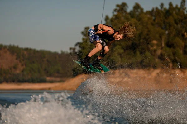 Great photo shot of man masterfully jumping over splashing wave on wakeboard — Photo
