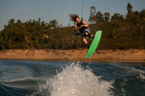 İnsanoğlunun Wakeboard 'da uçan dalgaların üzerinden ustalıkla atlarken çekilmiş fotoğrafı.