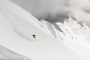 İnsansız hava aracından tepeden inen adam Freerider 'ın manzarası harika. Dağlarda kayak turu, ekstrem spor