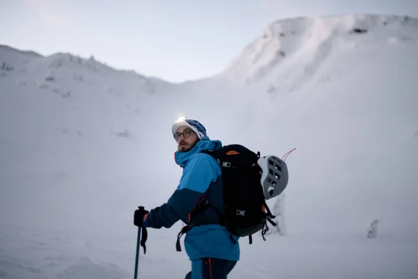 穿着鲜艳夹克的男子滑雪者正在用滑雪板设备爬山 滑雪带着令人惊奇的山景游览 — 图库照片