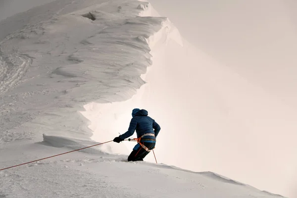 晴れた冬の日に雪の山のスキー用具と明るいジャケットで勇敢なスキーヤーの素晴らしい眺め — ストック写真