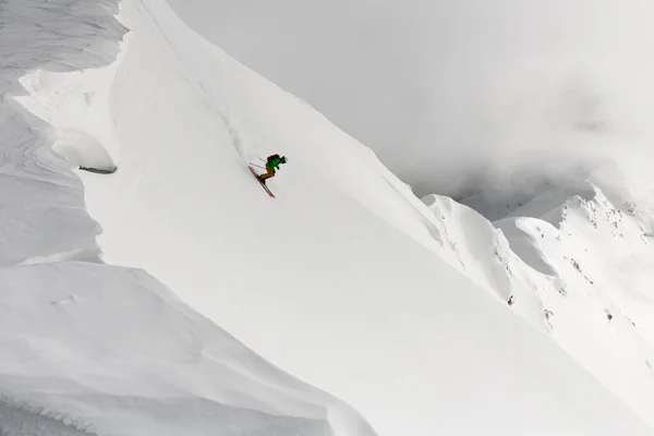 从无人驾驶飞机上俯瞰从山脊顶上下来的人 滑雪游览高山 极限运动 — 图库照片