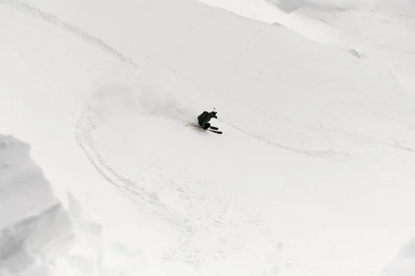在阳光明媚的冬日 一个活跃的人在雪白的雪山上滑行 冬季活动 在山上打滚 — 图库照片