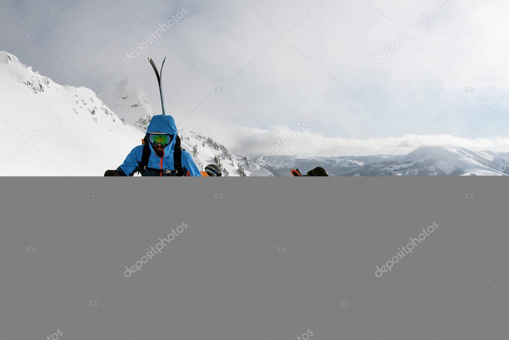 Active people climbing snowy hill on mountain on skis and splitboards at sunny winter day. Winter activities, ski touring