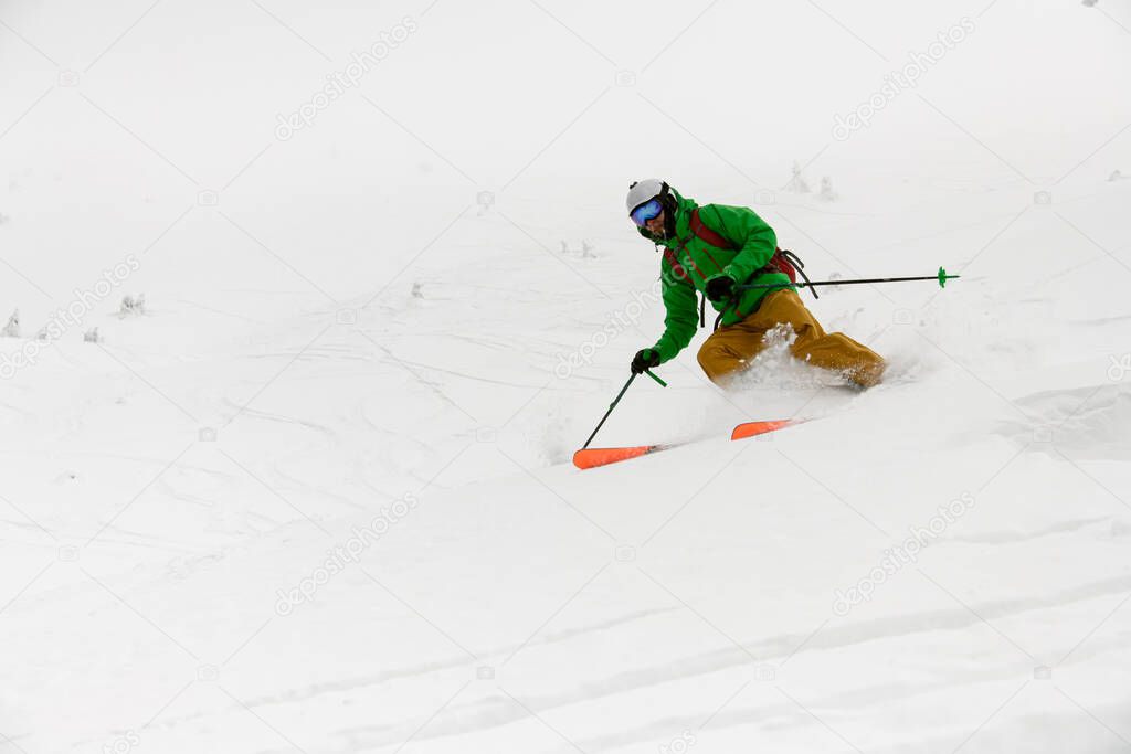 close-up view of active athlete riding down snow-covered mountain on splitboard. Skitouring in beautiful winter powder snow.
