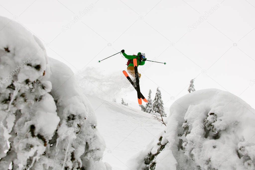 great view of athlete skier in bright jacket skilfully jumping over slopes of snow-capped mountains