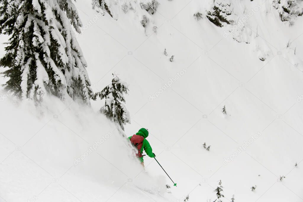 Snowboarder riding down in avalanche track terrain during as part of fun, danger, extreme, high avalanche danger, splitboard
