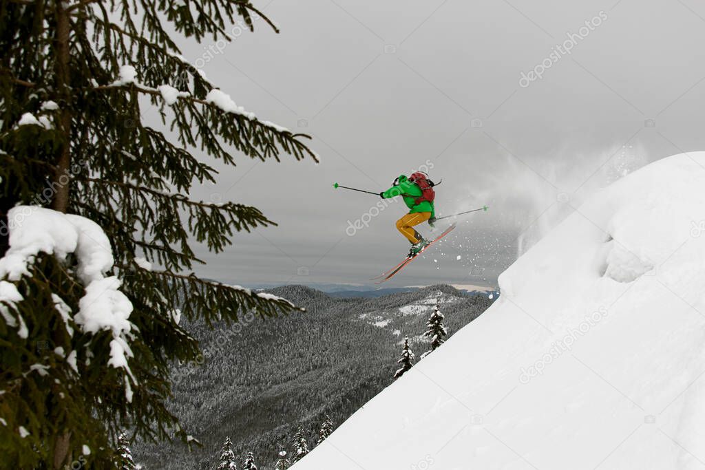 magnificent view of athlete skier in bright jacket skilfully jumping over slopes of snow-capped mountains