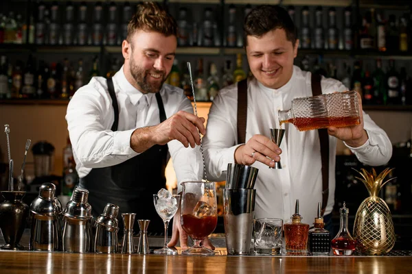 Barda Iki Erkek Barmen Kokteyl Hazırlıyor Biri Şişeden Çeliğe Dolduruyor — Stok fotoğraf