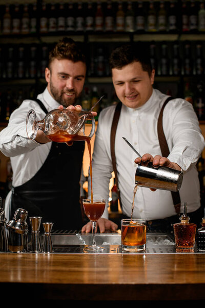 Two Bartenders Preparing Cocktails One Pouring Drink Glass Mixing Cup Royalty Free Stock Photos