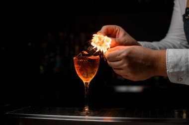 Şarap kadehini buzlu bir içecekle görmek ve barmenin ellerini sıçratıp ateşe vermek.