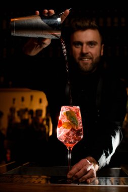 Buzlu çilek ve barmenlerin karıştırıcıdan doğru kokteyl döktüğü naneli bardakla güzel bir manzara.